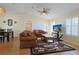 Spacious living room features wood floors, comfortable seating, ceiling fan, and large TV for entertainment at 17490 Se 110Th Ter, Summerfield, FL 34491