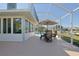 Screened-in patio features an outdoor dining set and view of the pool and backyard, ideal for entertaining at 17490 Se 110Th Ter, Summerfield, FL 34491