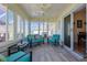 Bright sunroom with tile flooring, ceiling fan, and cozy seating, perfect for relaxation and enjoying the view at 17490 Se 110Th Ter, Summerfield, FL 34491