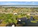Aerial view of a lakeside property with a private dock nestled among mature trees and well-manicured lawns at 17648 Live Oak Dr, Tavares, FL 32778
