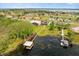 Aerial view of a lakefront property with a dock, expansive lawn, and mature trees, showcasing luxury living at 17648 Live Oak Dr, Tavares, FL 32778