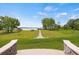 Expansive backyard featuring a stone walkway leading to a private dock on the serene lake at 17648 Live Oak Dr, Tavares, FL 32778
