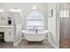 Bright bathroom featuring a soaking tub in front of a decorative window and a glass shower at 17648 Live Oak Dr, Tavares, FL 32778