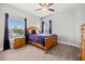 Bedroom featuring a window view, ceiling fan, and a bed with purple bedding at 17648 Live Oak Dr, Tavares, FL 32778