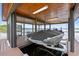 View of boat dock with lift, covered area, and screened in sitting area overlooking the water at 17648 Live Oak Dr, Tavares, FL 32778