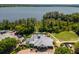 Aerial view of the clubhouse featuring a pool, lakeside access, and beautifully landscaped grounds at 17648 Live Oak Dr, Tavares, FL 32778