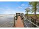 Waterfront home featuring a private wooden dock with a covered boat lift and serene lake views at 17648 Live Oak Dr, Tavares, FL 32778