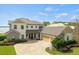 Stunning two-story home with a metal roof, stone accents, manicured landscaping, and a spacious driveway at 17648 Live Oak Dr, Tavares, FL 32778