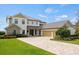 Stunning two-story home with a brick driveway and a three-car garage at 17648 Live Oak Dr, Tavares, FL 32778