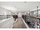 Upstairs hallway with wood look floors and decorative railing overlooking the great room at 17648 Live Oak Dr, Tavares, FL 32778