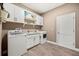 Spacious laundry room with storage cabinets, sink and granite countertops at 17648 Live Oak Dr, Tavares, FL 32778