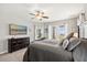 Comfortable main bedroom suite with a ceiling fan, TV, dresser, and access to the backyard at 17648 Live Oak Dr, Tavares, FL 32778