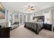 Spacious main bedroom with plush carpet, ceiling fan, private patio doors, and serene views at 17648 Live Oak Dr, Tavares, FL 32778