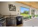 Outdoor kitchen with stainless grill, stone accents, mini fridge, and sliding glass doors to the patio at 17648 Live Oak Dr, Tavares, FL 32778