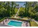 Resort-style pool area with comfortable seating and umbrella, nestled near a scenic lake and dock at 17648 Live Oak Dr, Tavares, FL 32778