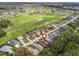 Aerial view of a home with a golf course in the background, showcasing its desirable location at 17728 Se 115Th Ct, Summerfield, FL 34491