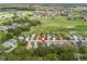 Aerial view of a neighborhood with a golf course in the background, pinpointing the property at 17728 Se 115Th Ct, Summerfield, FL 34491