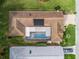 Overhead aerial view of home with screened pool, solar panels and a brick paver driveway at 17728 Se 115Th Ct, Summerfield, FL 34491