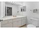 This bathroom includes a large mirror with vanity lighting, plenty of storage, and a toilet at 17728 Se 115Th Ct, Summerfield, FL 34491