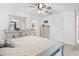This carpeted bedroom has neutral decor, a ceiling fan, plenty of closet space, and an ensuite bathroom at 17728 Se 115Th Ct, Summerfield, FL 34491