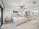 Bright, carpeted main bedroom features contemporary decor, ceiling fan, and an ensuite bathroom for added privacy at 17728 Se 115Th Ct, Summerfield, FL 34491