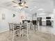 Open-concept dining area with modern table, adjacent to kitchen with granite countertops at 17728 Se 115Th Ct, Summerfield, FL 34491