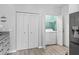 Convenient laundry closet with modern washer located just off the kitchen and concealed with white bi-fold doors at 17728 Se 115Th Ct, Summerfield, FL 34491