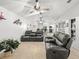 Bright and airy living room with vaulted ceilings, ceiling fans, and modern leather furniture at 17728 Se 115Th Ct, Summerfield, FL 34491