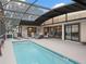 Screened-in pool area with a sparkling pool, comfortable seating, and ample space for relaxation and entertaining at 17728 Se 115Th Ct, Summerfield, FL 34491