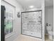 Updated, glass enclosed shower with a white marble look tile surround plus a handheld shower head at 17728 Se 115Th Ct, Summerfield, FL 34491