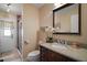 Well-lit bathroom featuring granite counters, decorative accents, and a tiled shower at 1945 Maple Cir # 45E, Tavares, FL 32778