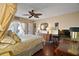 Bright bedroom showcasing hardwood floors, ceiling fan, and access to an outdoor area with a private entrance at 1945 Maple Cir # 45E, Tavares, FL 32778