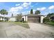 Charming single-story home featuring a two-car garage, well-maintained landscaping and a beautiful sky at 1945 Maple Cir # 45E, Tavares, FL 32778