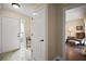 Bright foyer with tile flooring, white door, and view into a beautifully staged bedroom at 1945 Maple Cir # 45E, Tavares, FL 32778