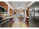Kitchen overlooking dining area with stainless steel refrigerator, matching cabinetry and tile flooring at 1945 Maple Cir # 45E, Tavares, FL 32778