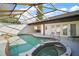 Enclosed pool and jacuzzi area with an angular ceiling and lounging furniture at 1945 Maple Cir # 45E, Tavares, FL 32778