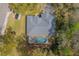 Birds eye view of a grey roofed home featuring a screened-in pool and a patio at 19666 Sw 88Th Loop, Dunnellon, FL 34432
