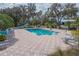 Community pool with lounge chairs and tables, set within a lush, tropical landscape at 19666 Sw 88Th Loop, Dunnellon, FL 34432