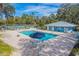 Community pool featuring a lounge area and a covered gathering space with a tennis court in the background at 19666 Sw 88Th Loop, Dunnellon, FL 34432