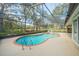 Screened-in pool featuring brick trim, jacuzzi, and landscaping at 19666 Sw 88Th Loop, Dunnellon, FL 34432