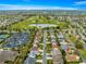 Aerial view showing house location with a red arrow, golf course, and parking lot at 2136 Kerwood Loop, The Villages, FL 32162