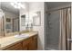 Bathroom featuring a single sink vanity, shower, and a well-lit mirror, offering modern amenities at 2136 Kerwood Loop, The Villages, FL 32162