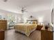 Bright bedroom features a ceiling fan, wood-look floors, neutral walls, and window views at 2136 Kerwood Loop, The Villages, FL 32162