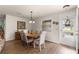 Cozy dining room features a round table, wood floors, a decorative light fixture, and neutral-colored walls at 2136 Kerwood Loop, The Villages, FL 32162
