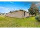 Exterior view of house with siding, green lawn, mature landscaping, and AC unit at 2136 Kerwood Loop, The Villages, FL 32162