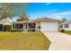 Charming single-story home featuring a well-maintained lawn, landscaping, and attached garage at 2136 Kerwood Loop, The Villages, FL 32162