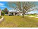 Charming home with a well-manicured lawn, mature tree, and cozy screened-in porch at 2136 Kerwood Loop, The Villages, FL 32162