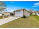 Charming home featuring a two-car garage with a well-maintained lawn and inviting curb appeal at 2136 Kerwood Loop, The Villages, FL 32162