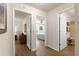 Hallway showing doors to the bathroom and bedroom, plus wood-look floors at 2136 Kerwood Loop, The Villages, FL 32162