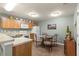 The kitchen includes a dining area with a glass table and wrought iron chairs plus light wood cabinets and white appliances at 2136 Kerwood Loop, The Villages, FL 32162
